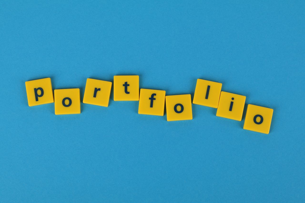 services-02 Des tuiles de Scrabble jaunes sur un fond bleu formant le mot portfolio. Idéal pour les thèmes liés aux affaires.